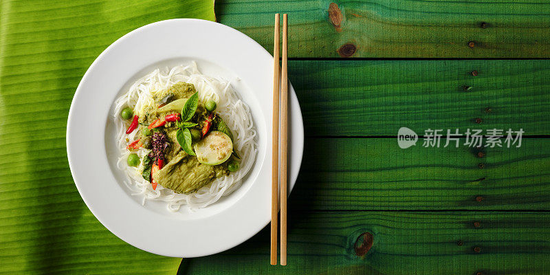 著名的国际知名泰国绿色椰子咖喱“Gaeng Keow Wan Gai”，鸡肉放在新鲜的泰国米粉上，在一道菜中，用传统的筷子。